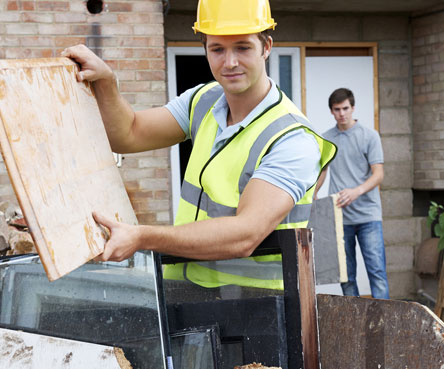 man removing wood from home